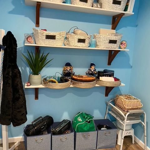 Mudroom in a new addition with wall shelves, baskets and storage cubes