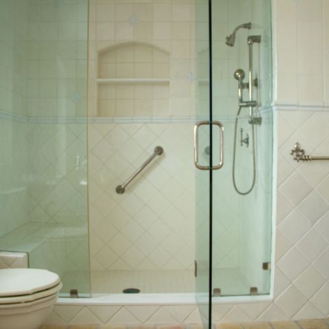 Frameless glass shower with a built-in niche beside a carved wood vanity