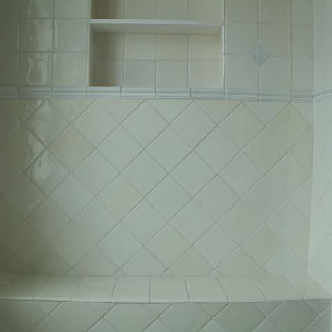 Tiled shower bench with a recessed niche and a blue border