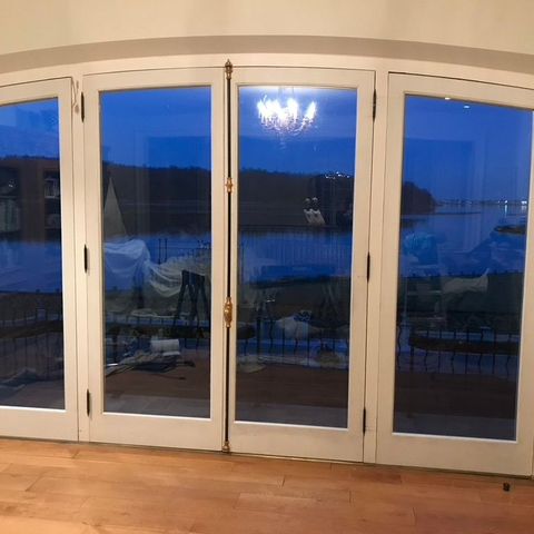 Folding glass doors opening onto the water at dusk