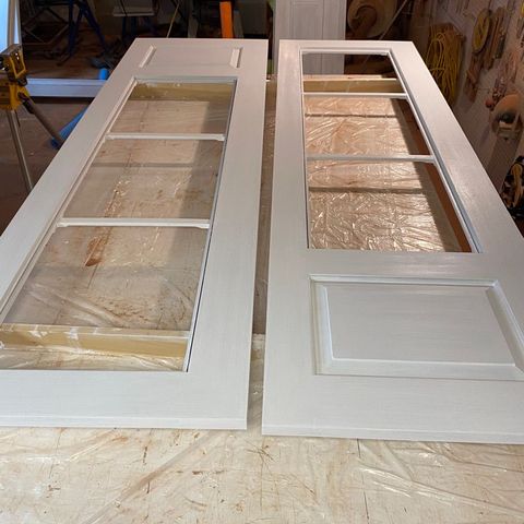 Two glazed doors primed and drying in the shop