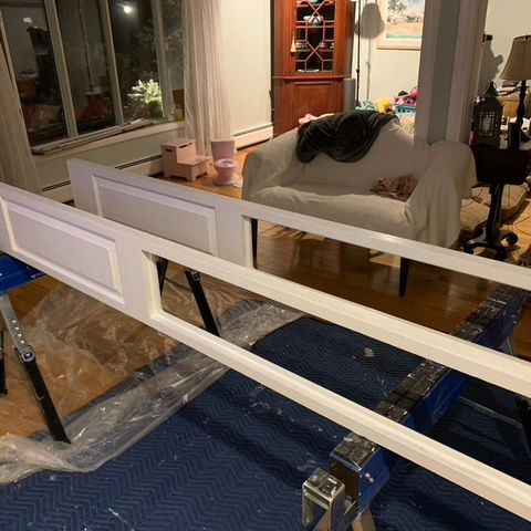Painted window sashes on sawhorses, ready to install