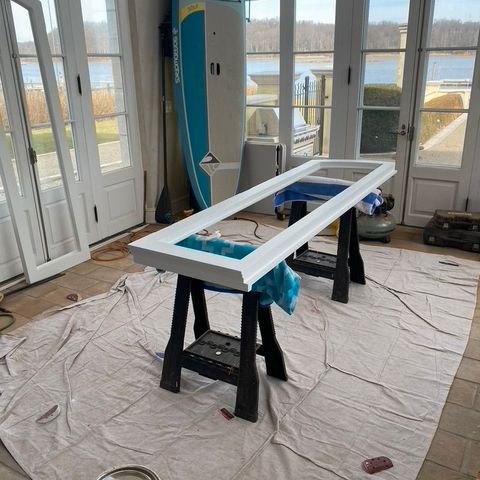 Window sash on sawhorses beside the French doors it was built for