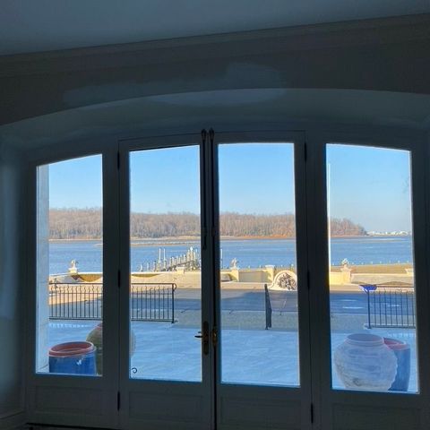 Arched French doors and windows overlooking a waterfront patio