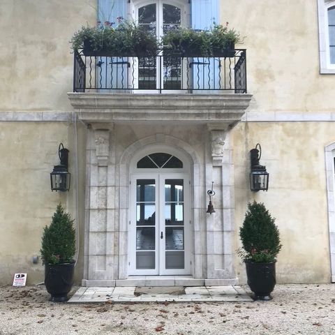 Arched French doors and a balcony on a stucco facade