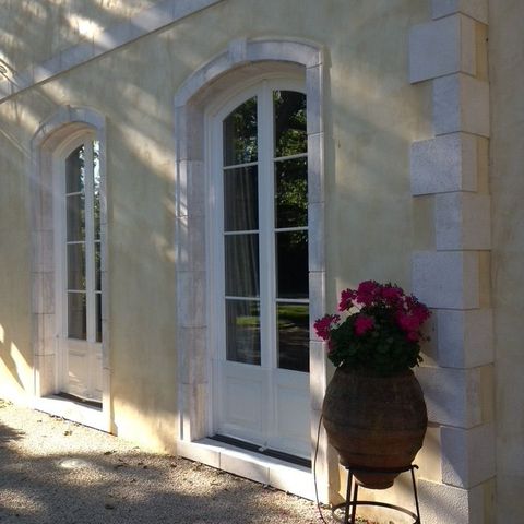 Tall arched French doors set in stone surrounds