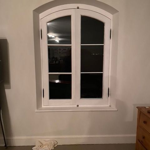 Arched casement window set into a deep plaster reveal
