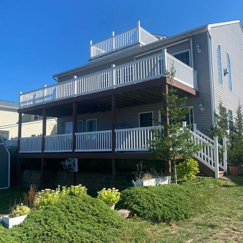 Two-level deck with white railings on the back of a shore house