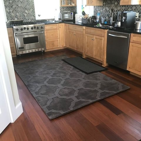 Maple kitchen with a stainless range hood and a grey tile backsplash