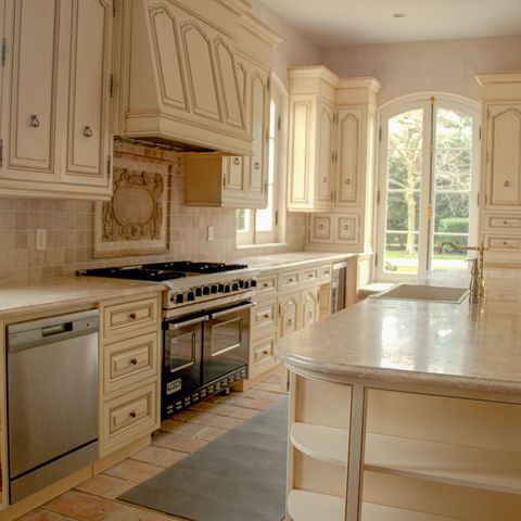 Kitchen with a six-burner range, cream cabinets and a long island