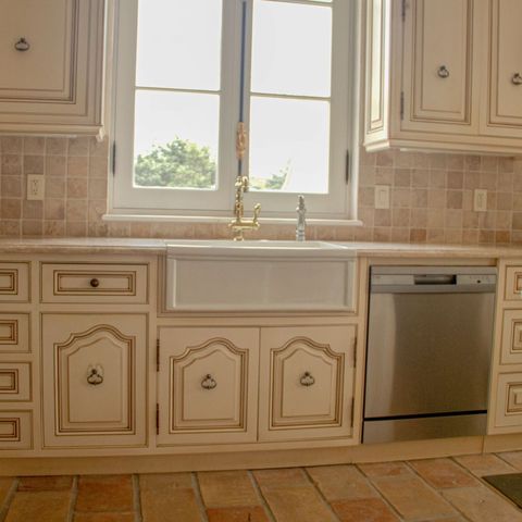 Farmhouse sink under twin windows with a tile backsplash