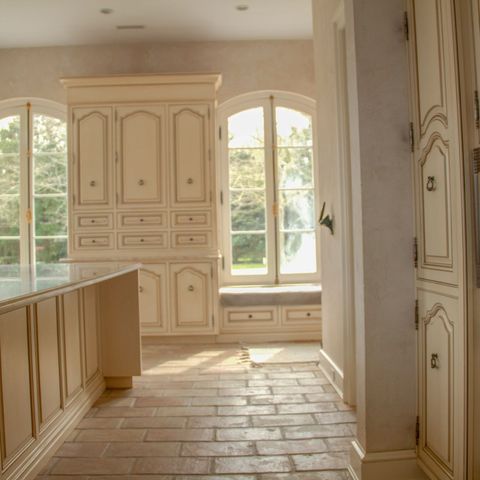 Cream kitchen with arched windows, a built-in microwave and an island