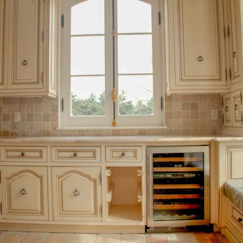Sink wall with a built-in wine refrigerator and a tile backsplash