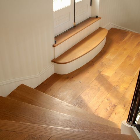 Oak winder stairs curving up to a landing