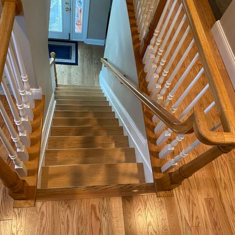 Oak staircase with a stained handrail and white balusters