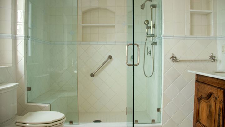 Frameless glass shower with a built-in niche beside a carved wood vanity
