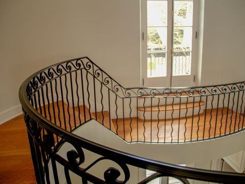 Curved stair landing with a wrought-iron railing